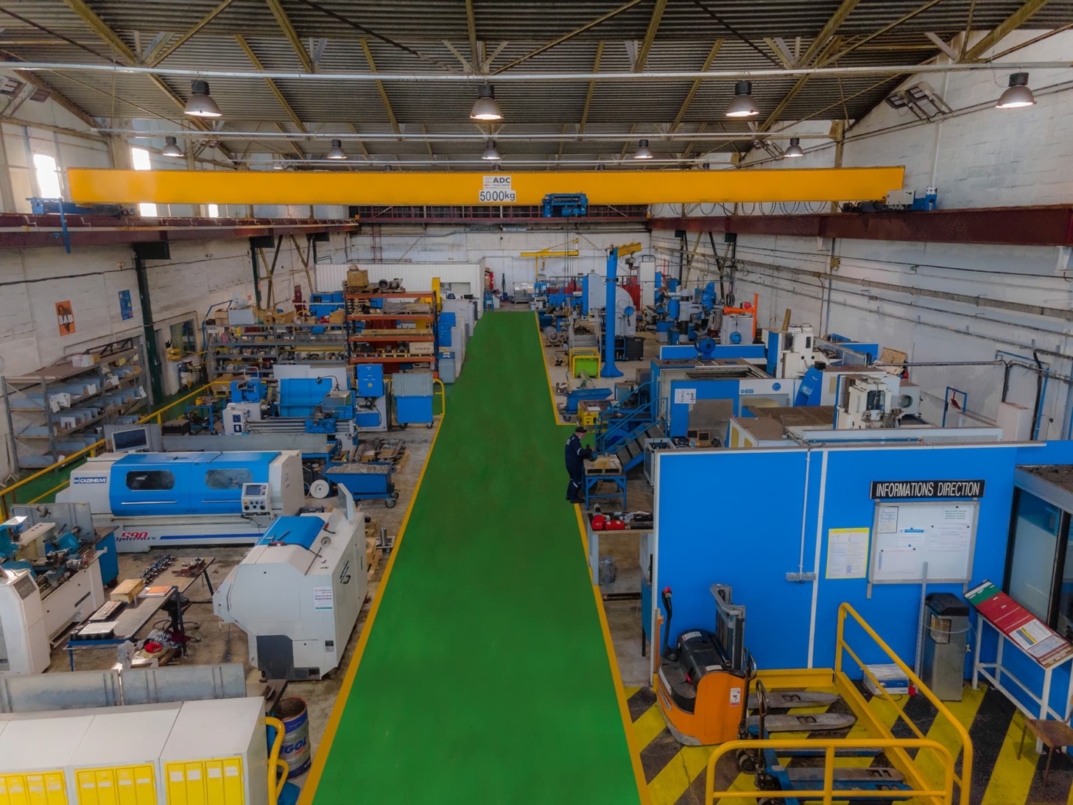 Vue intérieur des locaux de NP Industrie avec des machines industrielles en maintenance.